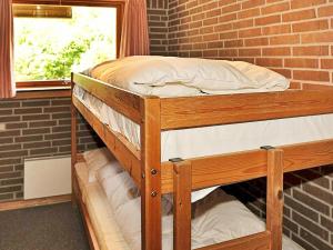 Ce lit se trouve dans un dortoir doté de 2 lits superposés et d'un mur en briques. dans l'établissement 4 person holiday home in Henne, à Henne Strand