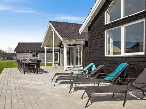 a patio with chairs and tables and a house at Holiday home Kappeln IV in Kappeln