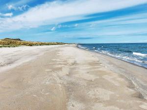 Ålbækにある8 person holiday home in lb kの砂浜と海の足跡が残る空のビーチ