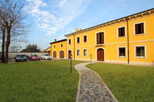 a yellow building with cars parked in a parking lot at Il Conte in San Bonifacio