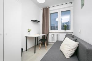 a living room with a couch and a table and a window at Rooms4Less in Gdańsk