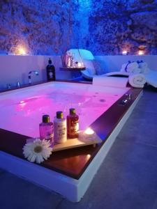 a spa tub with pink lighting and bottles of soap at Mastrangelo Suite & Spa in Palermo