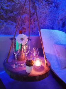 a table with wine glasses and candles on a swing at Mastrangelo Suite & Spa in Palermo
