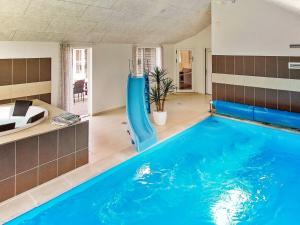 a large swimming pool with a slide in a house at Holiday home Kappeln IX in Kappeln