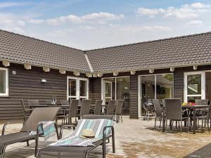a patio with chairs and tables and a building at Holiday home Kappeln IX in Kappeln