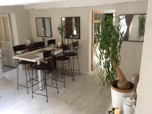 a dining room with a table and chairs and a potted plant at Abbey Road Le Thoureil in Le Thoureil