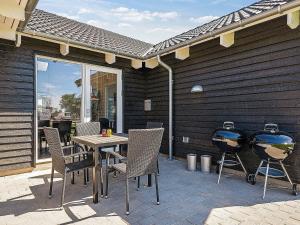 a patio with a table and two bbq fires at 16 person holiday home in Hasselberg in Kappeln