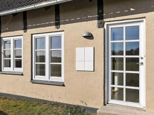 ボーゲンセにある4 person holiday home in Bogenseの三窓白い扉のある家