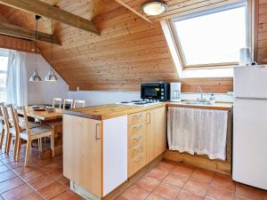 a kitchen with a refrigerator and a table in a room at 6 person holiday home in Ringk bing in Klegod