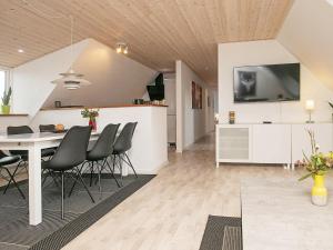 uma cozinha e sala de jantar com mesa e cadeiras em 6 person holiday home in S by em Sæby