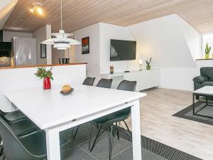uma sala de jantar e sala de estar com uma mesa branca e cadeiras em 6 person holiday home in S by em Sæby