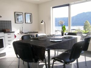 a dining room table with black chairs and a large window at 6 person holiday home in Sørbøvåg-By Traum in Sørbø