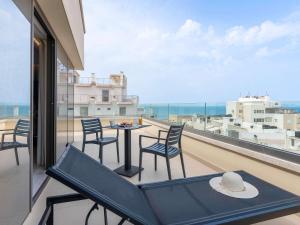 a balcony with a table and chairs and a view of the ocean at Ibis Styles Heraklion Central in Heraklio Town
