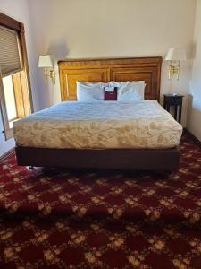 a bedroom with a large bed with a wooden headboard at Manresa Castle in Port Townsend