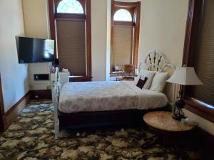 a bedroom with a bed and a flat screen tv at Manresa Castle in Port Townsend