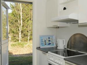 ブラーバンドにある6 person holiday home in Bl vandのキッチン(シンク、コンロ付)、窓が備わります。