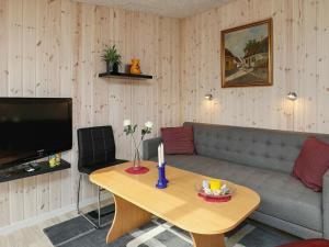 4 person holiday home in Vejers Strand في فايرس ستراند: غرفة معيشة مع أريكة وطاولة