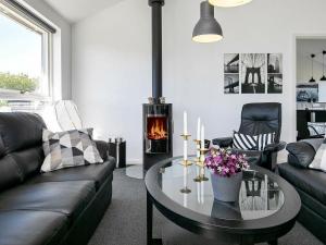 a living room with a coffee table and a fireplace at 6 person holiday home in L kken in Løkken