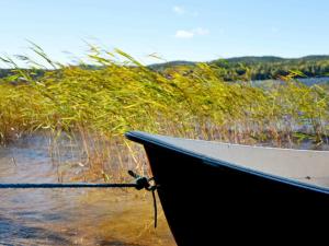 a boat sitting on the shore of a body of water at 7 person holiday home in Sunnemo in Sunnemo