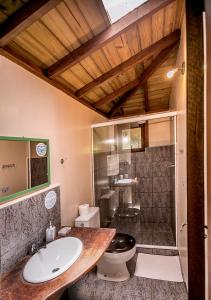 a bathroom with a sink and a toilet and a shower at Pousada The Rosebud in Praia do Rosa