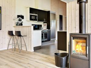 a kitchen with a fireplace in the middle of a room at 14 person holiday home in Stege in Stege