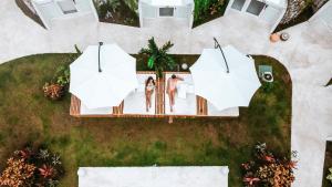 two women standing on a patio with umbrellas at Igloo Beach Lodge in Manuel Antonio