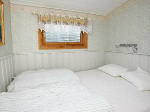 ブロックフスにあるTwo-Bedroom Holiday home in Blokhus 6のベッドルーム1室(ベッド2台、窓付)