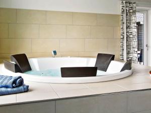 a bath tub with two chairs in a bathroom at 20 person holiday home in Hasselberg in Kappeln