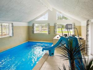 a indoor swimming pool with a slide in a room at 20 person holiday home in Hasselberg in Kappeln