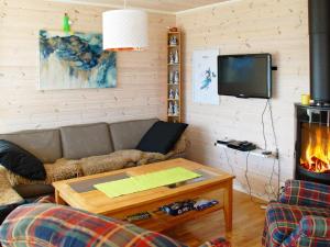 a living room with a couch and a fireplace at 6 person holiday home in Dønna in DÃ¸nnes