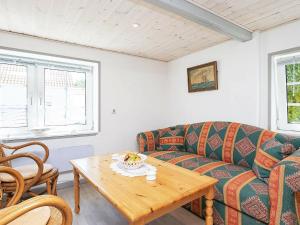 a living room with a couch and a table at 4 person holiday home in Asaa in Aså