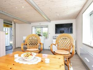 a dining room with a wooden table and chairs at 4 person holiday home in Asaa in Aså
