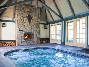 a swimming pool with a stone fireplace in a house at UCLA Lake Arrowhead Lodge in Lake Arrowhead