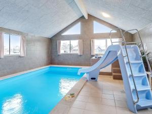 a indoor swimming pool with a slide in a house at 20 person holiday home in Grenaa in Grenå
