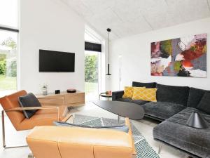 a living room with a couch and a tv at Three-Bedroom Holiday home in Tarm 12 in Hemmet