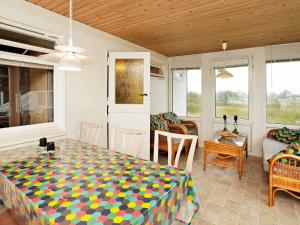 a room with a table and chairs and a couch at 6 person holiday home in R m in Bolilmark