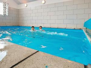 two children swimming in a swimming pool at 16 person holiday home in Glesborg in Fjellerup Strand