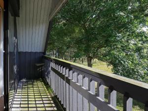 a porch of a house with a fence and a tree at 6 person holiday home in Struer in Struer