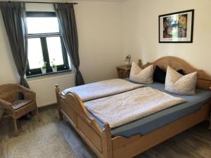 a bedroom with a wooden bed and a window at Wohnung in Dargun mit Garten in Barlin +27 photos