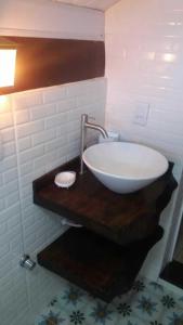 a sink on a wooden counter in a bathroom at Village dos Pássaros Apartamento in Guarapari