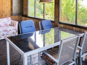 a glass table in a room with chairs and windows at 6 person holiday home in Str by in Strøby