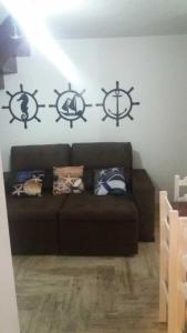 a living room with a couch and four anchors on the wall at Village dos Pássaros Apartamento in Guarapari