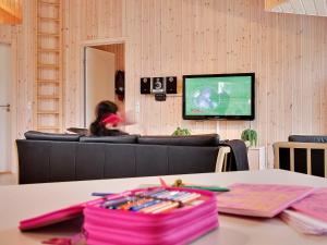 ティスヴィレライにある18 person holiday home in Tisvildelejeのソファ付きのテーブル、テレビが備わる客室です。