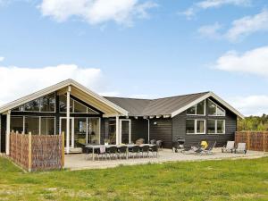 a house with a black roof and a patio at Seven-Bedroom Holiday home in Ålbæk in Ålbæk