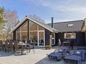 a house with a patio with a table and chairs at 14 person holiday home in Glesborg in Glesborg