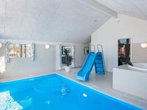 a indoor swimming pool with a slide and a blue slide at 14 person holiday home in Glesborg in Glesborg