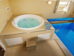 a bathroom with a tub with a swimming pool at 14 person holiday home in Glesborg in Glesborg