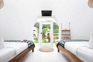 two beds in a room with a window at Igloo Beach Lodge in Manuel Antonio