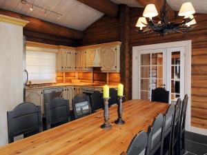 - une salle à manger avec une table et des chaises en bois dans l'établissement 12 person holiday home in F vang, à Tromsnes