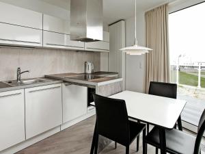a kitchen with white cabinets and a table and chairs at 3 person holiday home in Wendtorf in Wendtorf